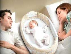 baby in bed with parents